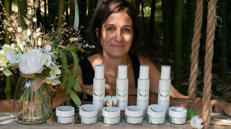 Vanessa Viguerie pose avec ses produits devant un champs de bambous.