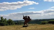La silhouette de la découpe de d'Artagnan sur son cheval que l'on voit à Lupiac avec la campagne en fond