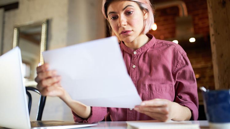 Entrepreneuse qui regarde ses factures devant son ordinateur. Crédit photo Freepik