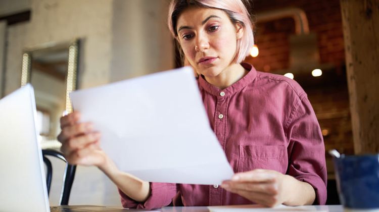 Entrepreneuse qui regarde ses factures devant son ordinateur. Crédit photo Freepik