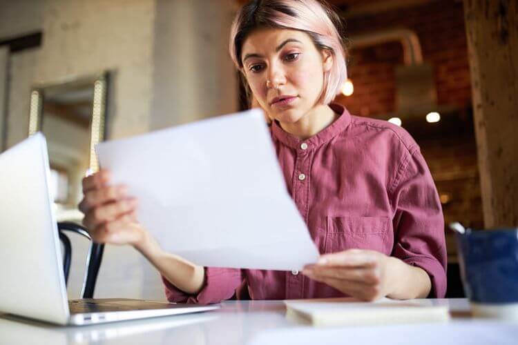 Entrepreneuse qui regarde ses factures devant son ordinateur. Crédit photo Freepik