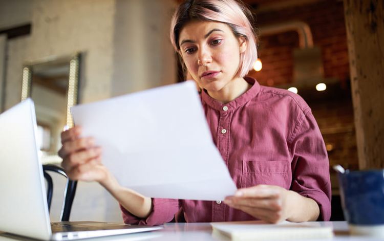 Entrepreneuse qui regarde ses factures devant son ordinateur. Crédit photo Freepik