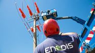 Un salarié Enedis en bas d'un pylône électrique.