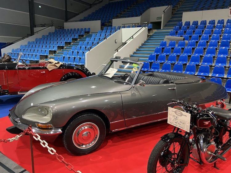 Une voiture grise décapotable et une moto de collection exposées lors de la bourse d'échange 2022 au Mouzon à Auch