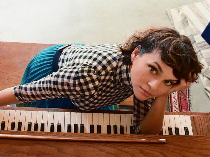 Une photo de Norah Jones appuyée sur le clavier d'un piano