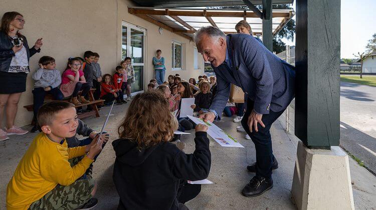 Xavier Fortinon, président du département des Landes, remet un chèque à un enfant dans le cadre de l'opération Un livre à tout âge.