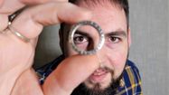 Nicolas Gutierrez regarde à travers l'un des anneaux qu'il a fabriqué.