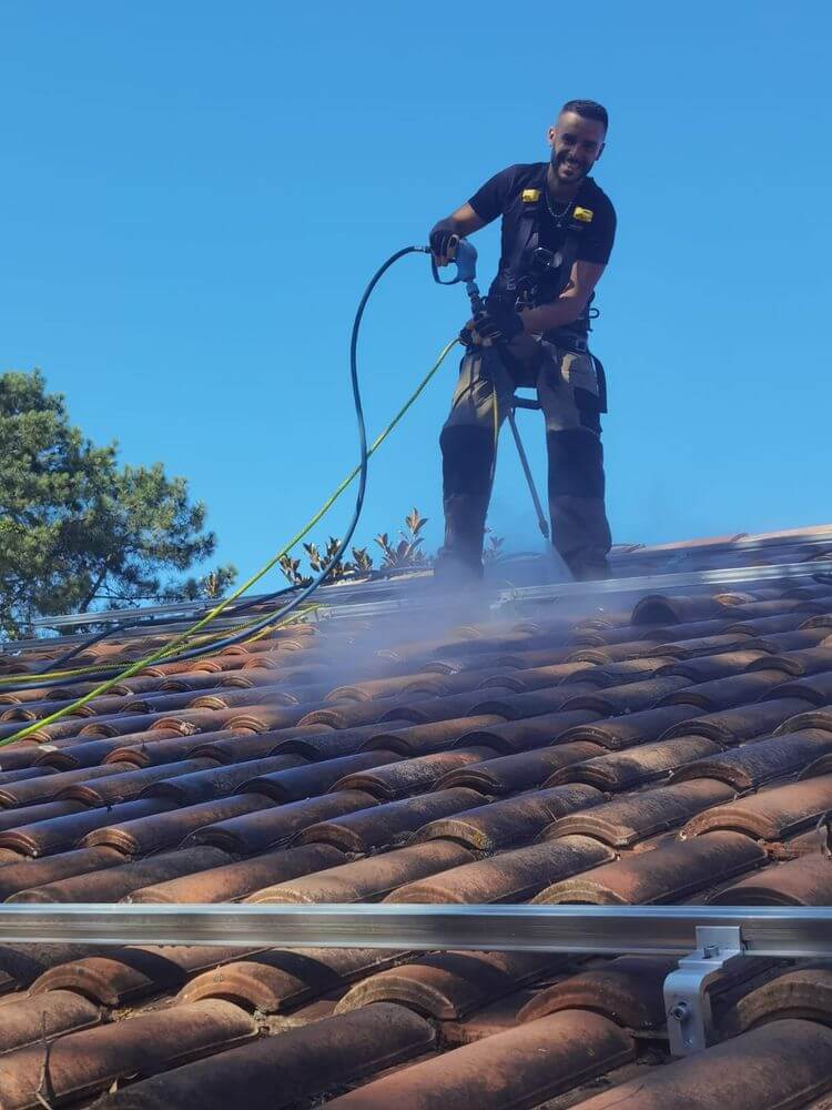 Jérémy Truffaut nettoie un toit grâce à de la vapeur.