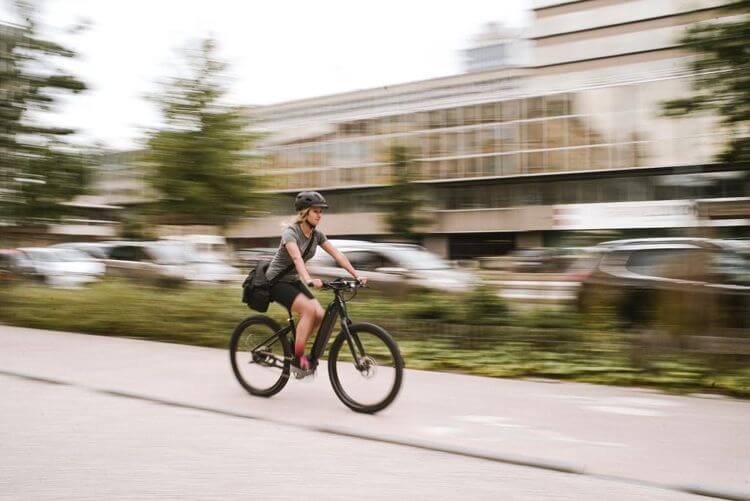 Une femme sur un vélo qui circule en ville