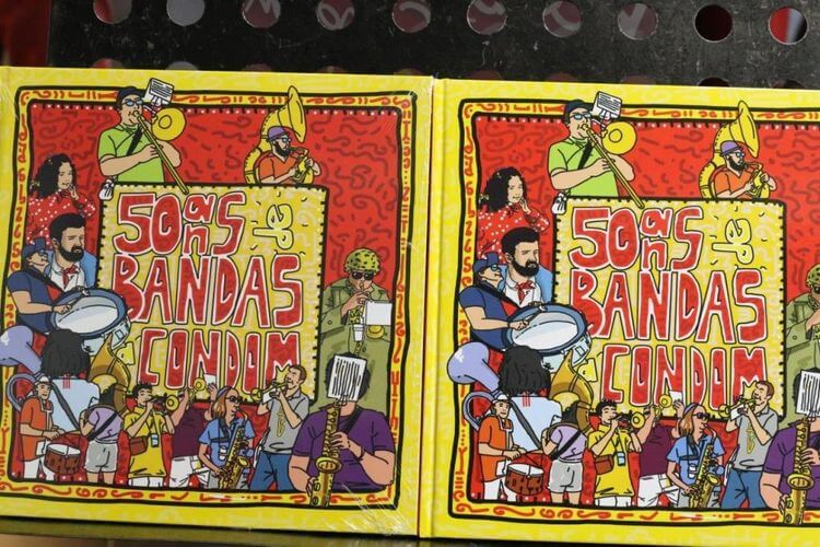 La couverture de l'album souvenirs des 50 ans avec des dessins de bandas, sur fond rouge et jaune