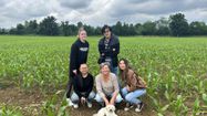 Corinne Delecroix entourée de quatre jeunes qui ont contribué à la mise en place du labyrinthe dans le champ de maïs