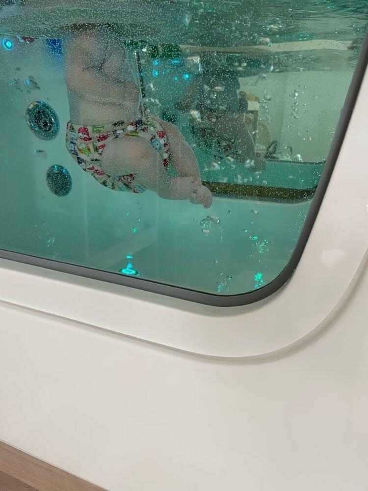 Un bébé dans une baignoire lors d'une séance d'hydrothérapie.