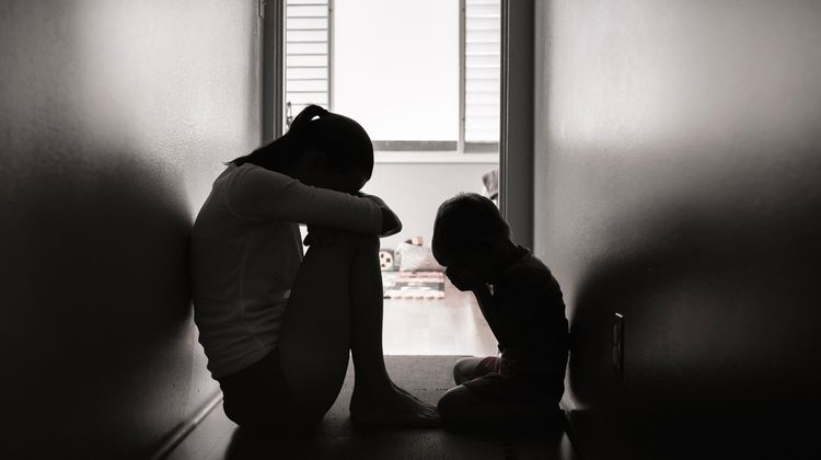 Une femme et son enfant sont assis dans un couloir.