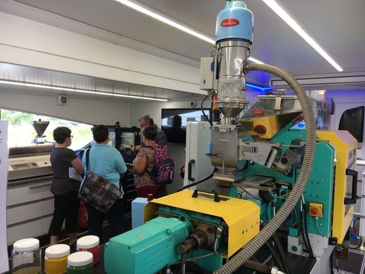 Des adultes visitent une usine avec des machines industrielles.