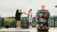 Un fût Drink Up est posé devant des gens qui font la fête.