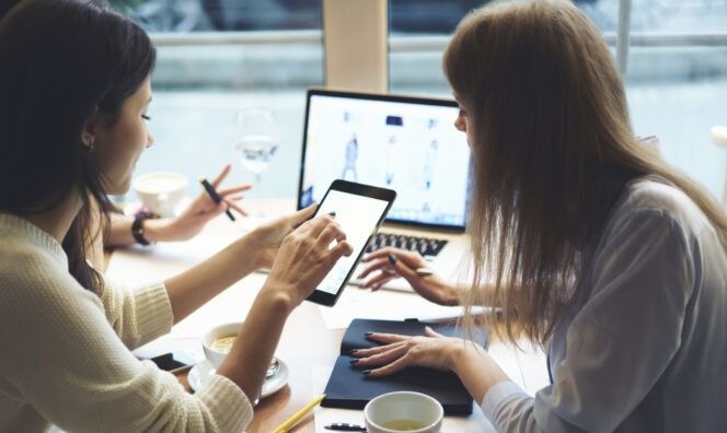 Deux femmes discutent autour d'une table.