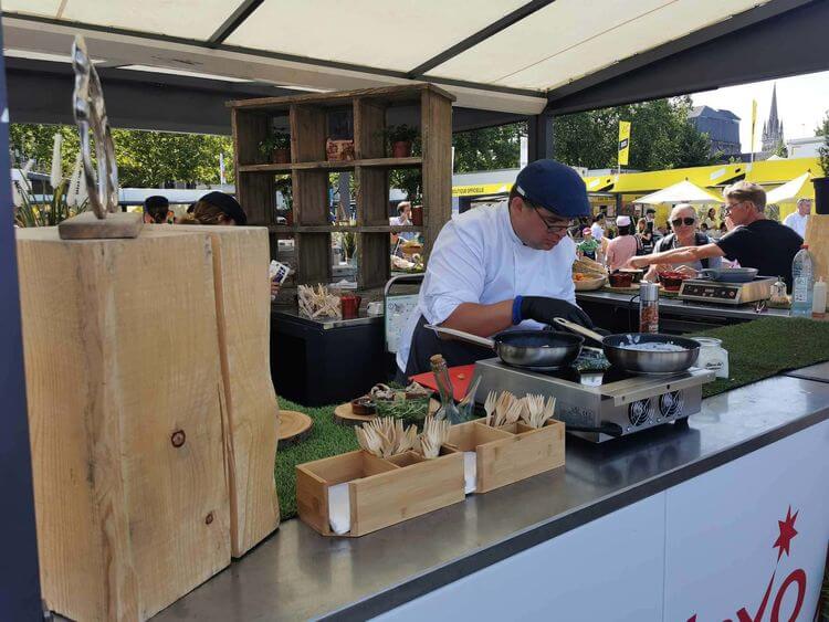 Un chef cuisinier aux fourneaux dans le Village-Départ du Tour de France de Pau.
