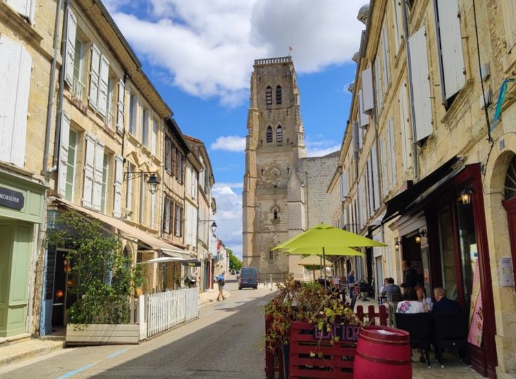 La rue principale de Lectoure avec la cathédrale en fond et des gens attablés en terrasse