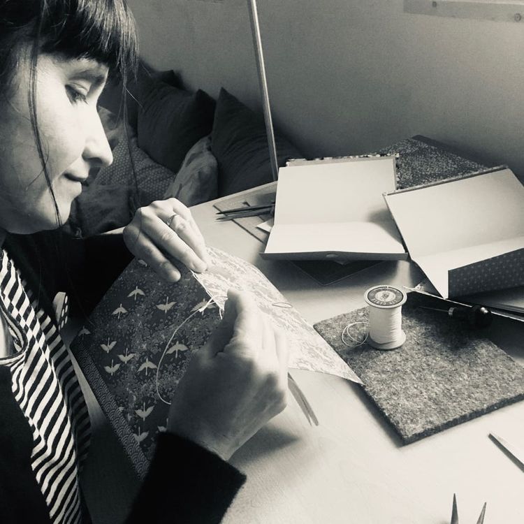 Marie Donnot en train de relier un livre, dans son atelier de Bielle, en Béarn