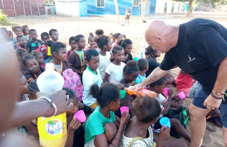 Jean Barrenechea sert à boire à des enfants à Madagascar.