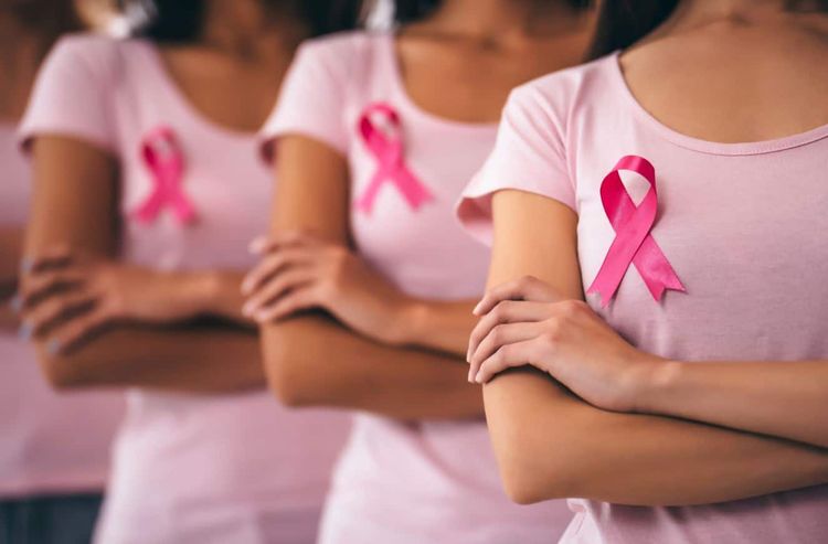 Des femmes en tshirt rose avec le symbole du ruban d'octobre rose sur la poitrine.