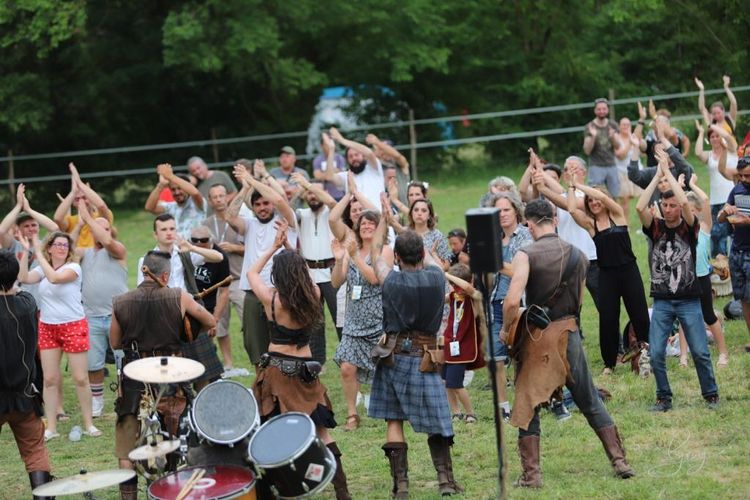 Des festivaliers en train de danser face à un groupe celtique