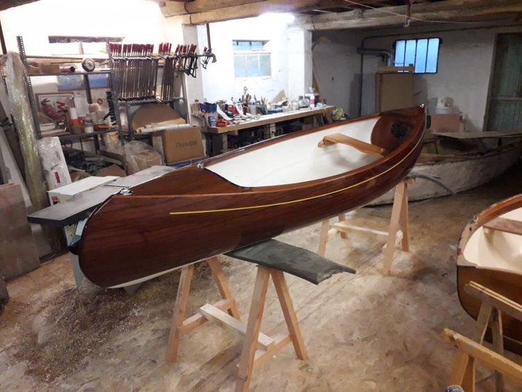 Une vue du canoë en bois vernis dans l'atelier de Marc Vuilliomenet