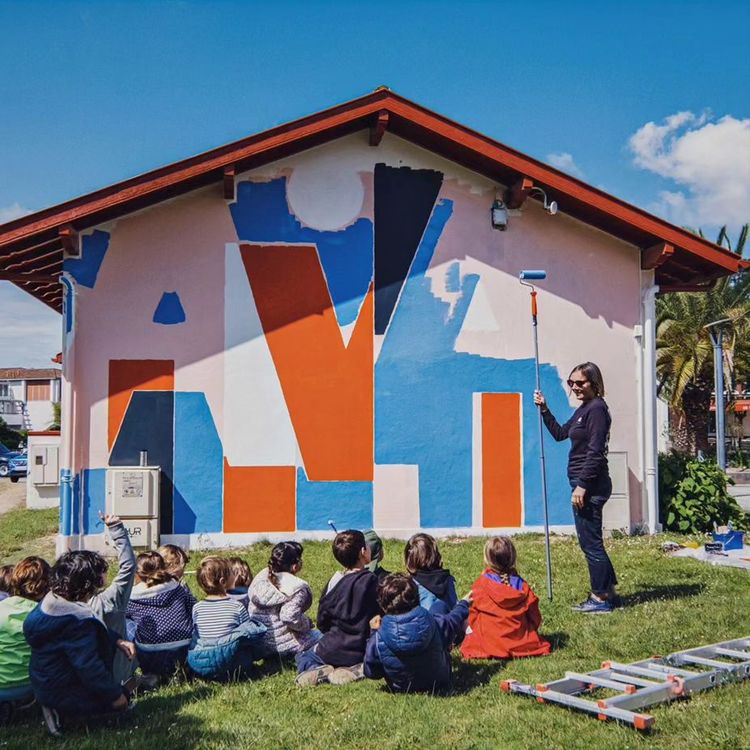 Une artiste discute avec des enfants devant le MUR de Seignosse.