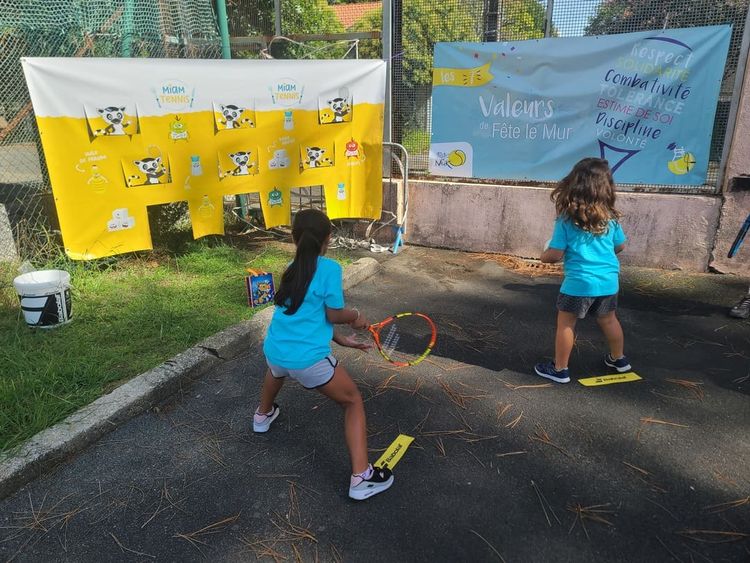 Deux jeunes filles jouent au tennis.