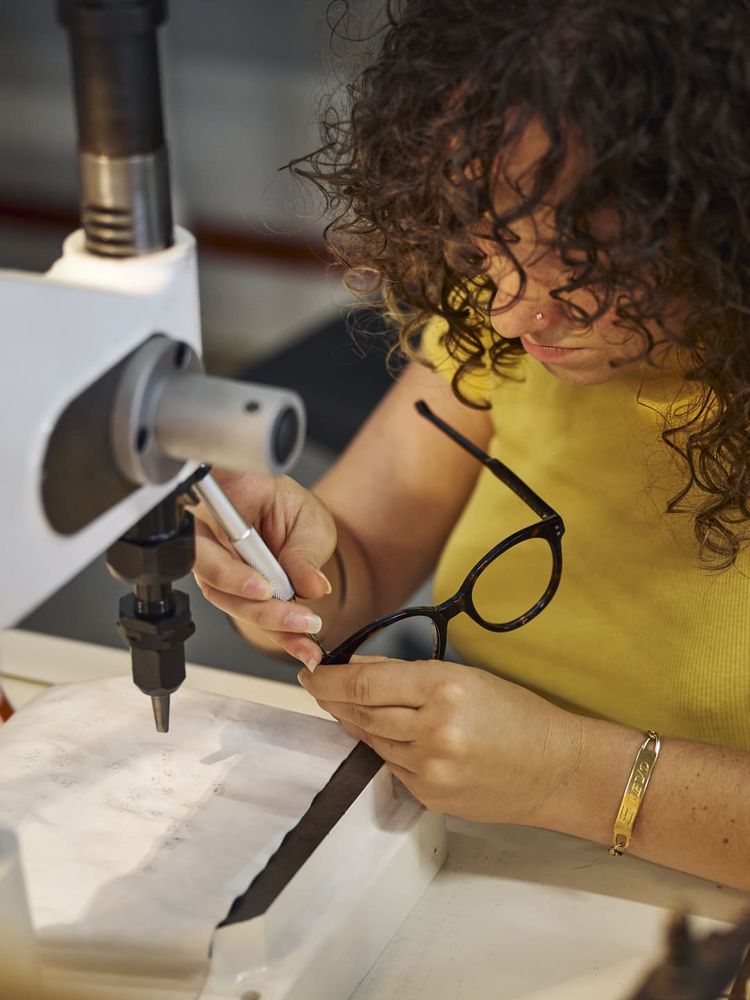 Une femme travaille sur des lunettes.