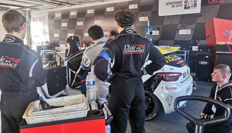 Des jeunes apprentis devant une voiture.