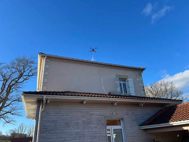 Drone nettoyant le toit d'une maison
