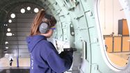 Une femme se forme à l'industrie aéronautique.