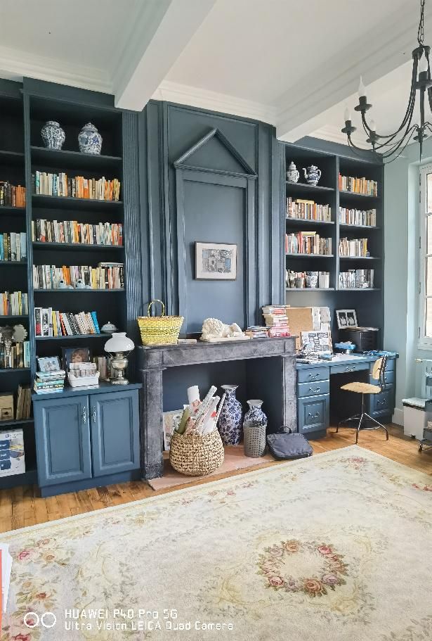 Un bureau avec grande cheminée et bibliothèque dans des tons de gris bleu