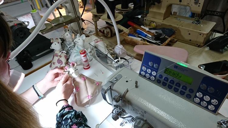 Une femme travaille sur un atelier à couture.