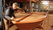Marc Vuilliomenet dans son atelier de Troncens, en train de travailler sur un bateau en construction