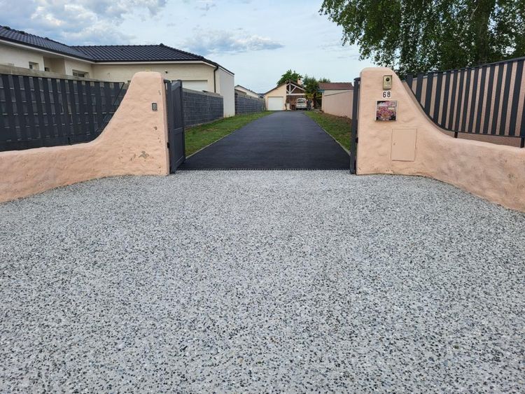 L'entrée d'une résidence faite par AGTP, avec portail ouvert donnant sur l'allée de la maison