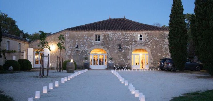 Une vue de Château Arton au crépuscule avec une allée illuminée et des cyprès de chaque côté