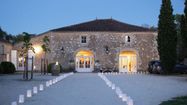 Une vue de Château Arton au crépuscule avec une allée illuminée et des cyprès de chaque côté