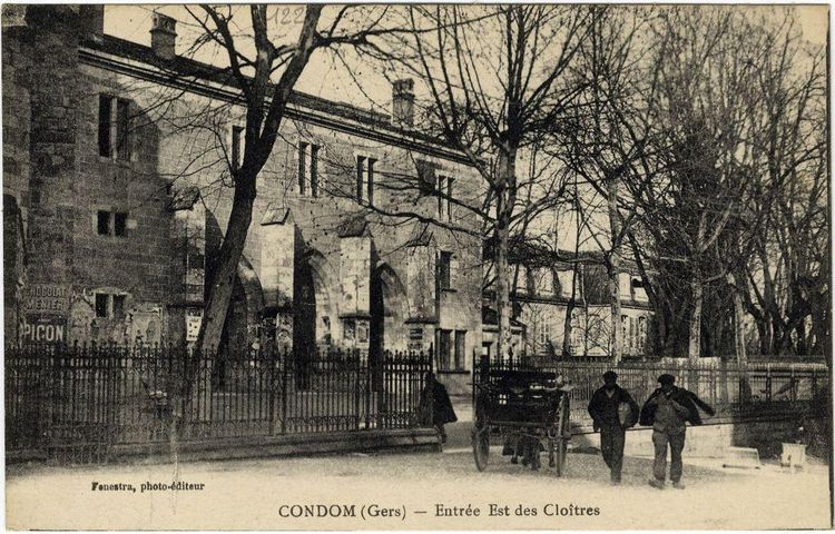 Une carte postale ancienne de l'entrée Est des cloîtres de Condom, avec des hommes et une charrette