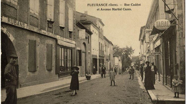 Une carte postale ancienne avec vue de la rue Cadéot à Fleurance, avec hommes, femmes et enfants