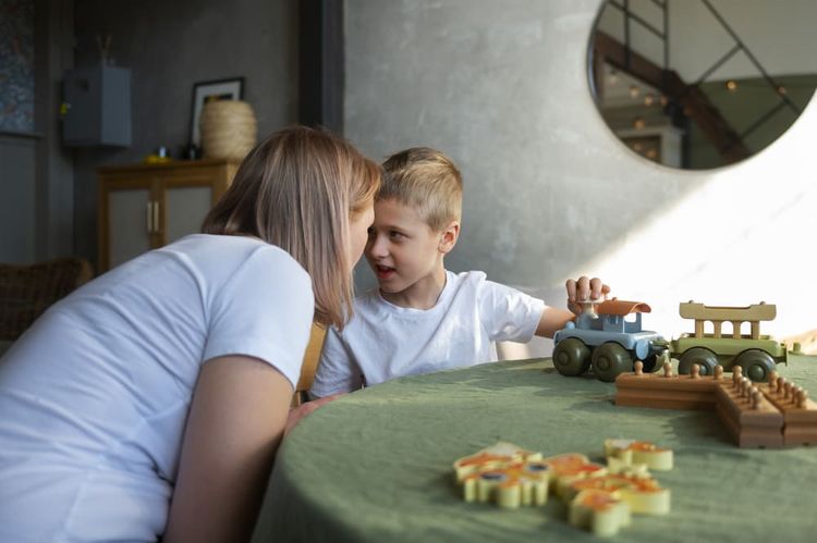 Un enfant autiste joue avec une adulte.